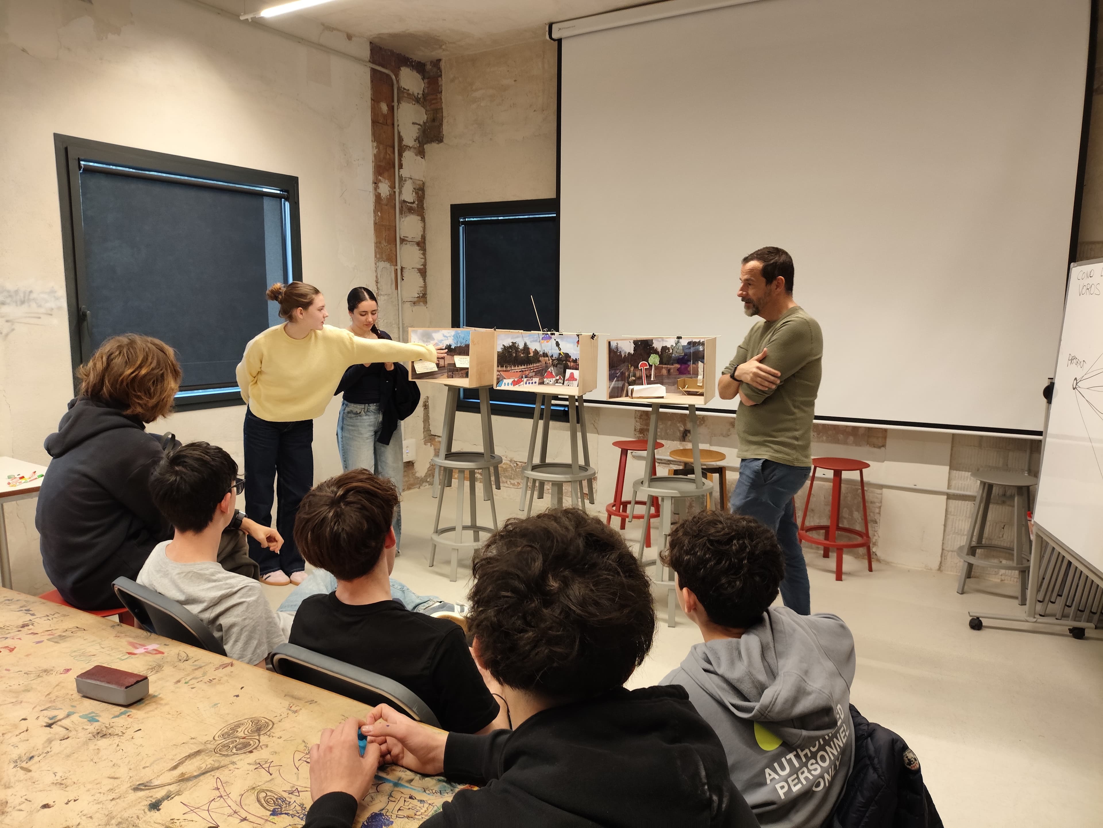 Estudiantes presentando dioramas ante un experto en EINA.