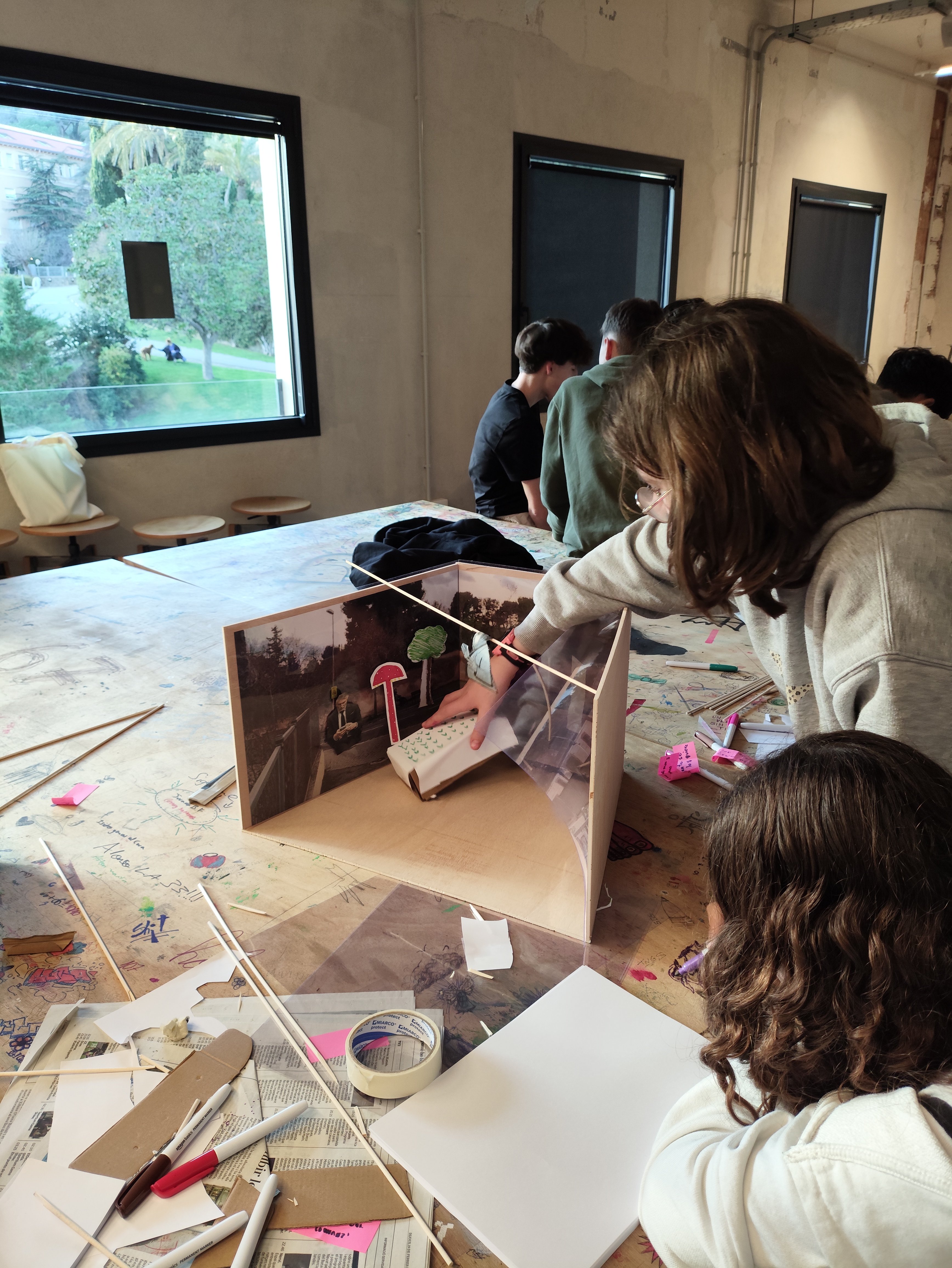 Manos de estudiantes creando maquetas en taller